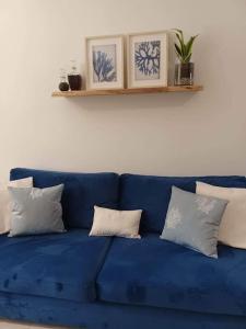 a blue couch with pillows on a white wall at Holiday House near Beach in Skala Fourkas