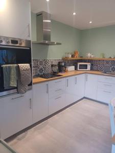 a kitchen with white cabinets and white appliances at Hillview in Daliburgh