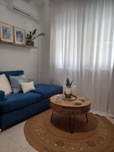 a living room with a blue couch and a coffee table at Holiday House near Beach in Skála Foúrkas