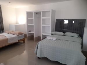 um quarto com 2 camas e uma cabeceira em La Posada 815 em Pisco