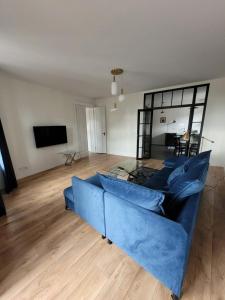 sala de estar con sofá azul y TV en Apartament Eliza - 2 Bathrooms! Best View Ever, en Toruń