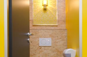 a bathroom with a toilet with a picture and a light at BaseCamp Bonn in Bonn +30 photos