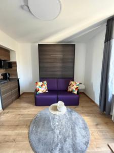 a living room with a purple couch and a table at Auberge de la Pétrusse in Luxembourg