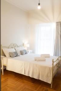 sypialnia z łóżkiem z białą pościelą i oknem w obiekcie AMALTHIA PIRAEUS w Pireusie