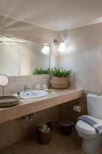 W łazience znajduje się umywalka, lustro i toaleta. w obiekcie AMALTHIA PIRAEUS w Pireusie