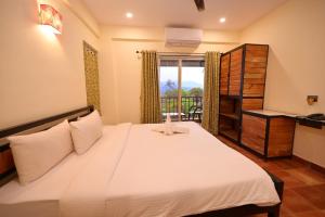 1 dormitorio con 1 cama grande y balcón en Forest Escapes Koyna en Koynanagar