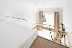 een slaapkamer met een wit bed en een raam bij Natalex MicroLofts in Vilnius +17 foto's