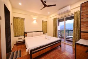 1 dormitorio con 1 cama y balcón en Forest Escapes Koyna en Koynanagar