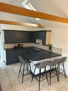 a kitchen with black cabinets and a table and chairs at The Old Stables in Mews in Kessingland