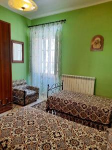 um quarto com 2 camas e paredes verdes em Nonna Domenica - Casa Vacanze @Gagliano Aterno em Gagliano Aterno