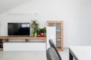 - un salon avec une télévision, une table et des chaises dans l'établissement I fiori del mare - YourPlace Abruzzo, à Francavilla al Mare