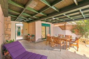 an outdoor patio with a wooden table and chairs at THERETRA KIOTARI VILLAS in Gennadi