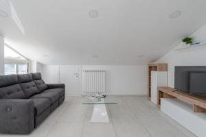 a living room with a couch and a television at I fiori del mare - YourPlace Abruzzo in Francavilla al Mare