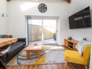 a living room with a couch and a table at Harvenna Cottage in Bude