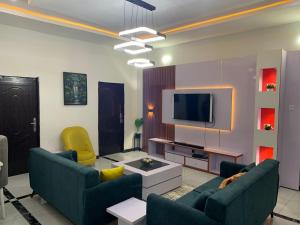 a living room with two couches and a tv at Luxury 1 Bedroom & Parlor Service Apartment with beautiful Amenities in Awoyaya