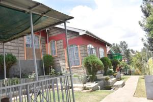 a house with a fence in front of it at 3-bedroom, 2-bedroom, 1-bedroom serenity homes in Langata Rongai