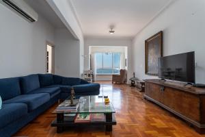 sala de estar con sofá azul y TV de pantalla plana en Sofisticado em Copacabana - 2 Suites - A801 en Río de Janeiro