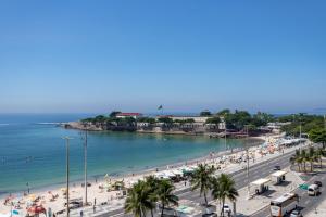 a beach with a bunch of people and the ocean at 2 minutos da praia de Copacabana - A801 in Rio de Janeiro