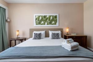 a bedroom with a large white bed with two lamps at 2 minutos da praia de Copacabana - A801 in Rio de Janeiro