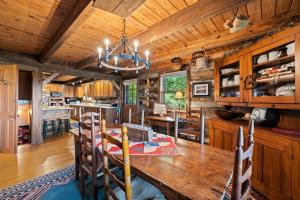 a dining room and kitchen with a wooden ceiling at Logs Of Luxury Cabin - Golfers Dream in Swiss