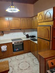 a kitchen with wooden cabinets and a stove top oven at Valsamo Luxury Cottage in Chaïdeftón
