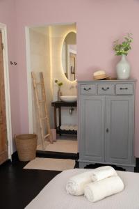 een badkamer met een wastafel en een blauwe kast met handdoeken bij Suite 137, luxe verblijf midden in de bollenstreek in Lisse