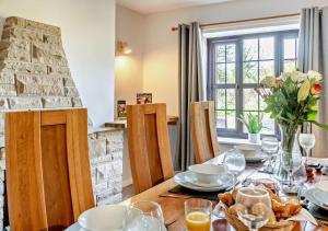 a dining room with a table and a fireplace at Chestnut Cottage - Stackpole in Stackpole Elidor