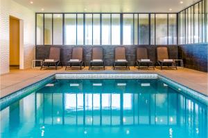 a swimming pool with chairs in a hotel room at Holiday Suites Nieuwpoort in Nieuwpoort