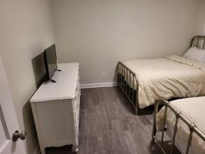 Cette chambre comprend deux lits et un bureau avec une télévision. dans l'établissement 5. Cozy cabin in Guntersville, à Guntersville