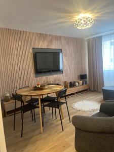 a living room with a table and a flat screen tv at ROMAN Residence Apartment in Borşa