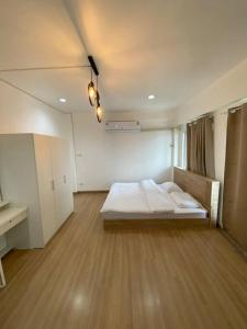 1 dormitorio con 1 cama y suelo de madera en Thanyaporn Guest House - Don Mueang, en Thung Si Kan