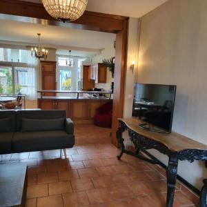 a living room with a couch and a table at Maison avec jardin et parking, au centre d'Etretat in Étretat