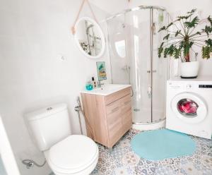 a bathroom with a toilet and a washing machine at Cool Canaria in Agaete