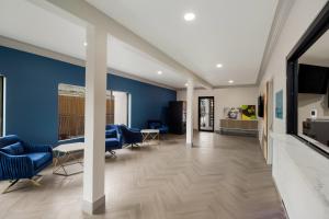 a living room with blue walls and a table and chairs at Signature Inn Houston Galleria in Houston