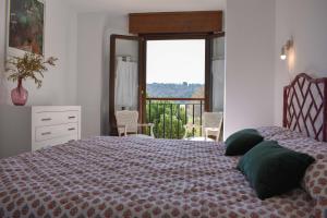 a bedroom with a bed with a view of a balcony at Sojuela Turismo Golf Naturaleza y VIno in Sojuela