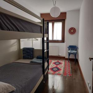 a bedroom with a bunk bed with a chair and a rug at Sojuela Turismo Golf Naturaleza y VIno in Sojuela