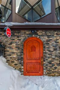 a red door on the side of a house at Chalet Hakuba in Hakuba