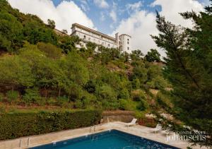 a swimming pool in front of a building at Pure Monchique Hotel - Villa Termal Spa Resort in Monchique
