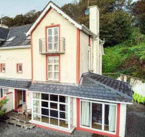 Casa blanca grande con balcón en la parte superior. en Ashton Beach House, en Tramore