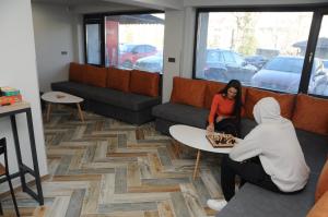 una donna seduta a un tavolo in un soggiorno di DORM BG pet-friendly Aparthotel a Stara Zagora Altre 81 foto