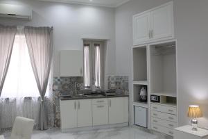 Una cocina con gabinetes blancos y una ventana. en Opera Home Napoli, en Nápoles