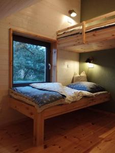 a bedroom with a bunk bed with a window at gemütliches Holzhaus am See in Warin