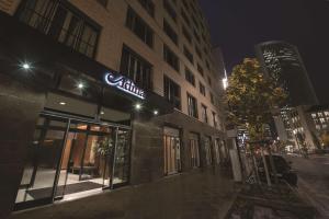 a building with a sign on the side of it at night at Adina Apartment Hotel Frankfurt Westend in Frankfurt/Main