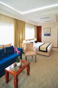 ein Hotelzimmer mit einem Bett und einem blauen Sofa in der Unterkunft Hotel Montenegrino in Tivat