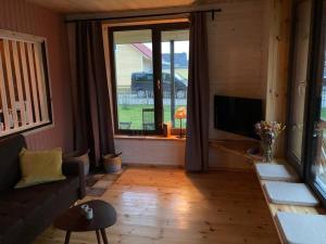 a living room with a couch and a large window at gemütliches Holzhaus am See in Warin