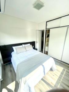Un dormitorio con una gran cama blanca y una escalera en Golf Tower Suites & Apartments en Buenos Aires