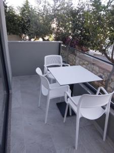 卡薩米里的住宿－Hotel Ksamili，阳台上配有白色的桌椅