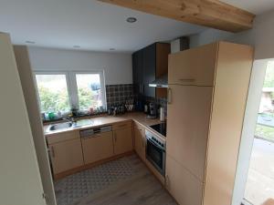 a kitchen with a refrigerator and a sink at Ferienhaus Wald&Wiese in Wilzenberg-Hußweiler
