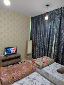 a room with two beds and a tv in it at Twins Room in Shared Apartment in Ajman 