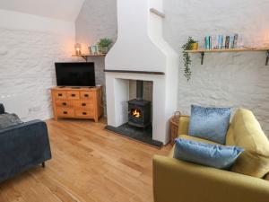 a living room with a yellow couch and a fireplace at Sands Cottage in Haverfordwest